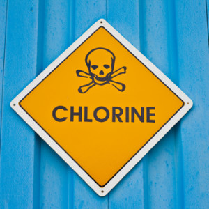 Yellow chlorine hazard warning sign on a blue wall